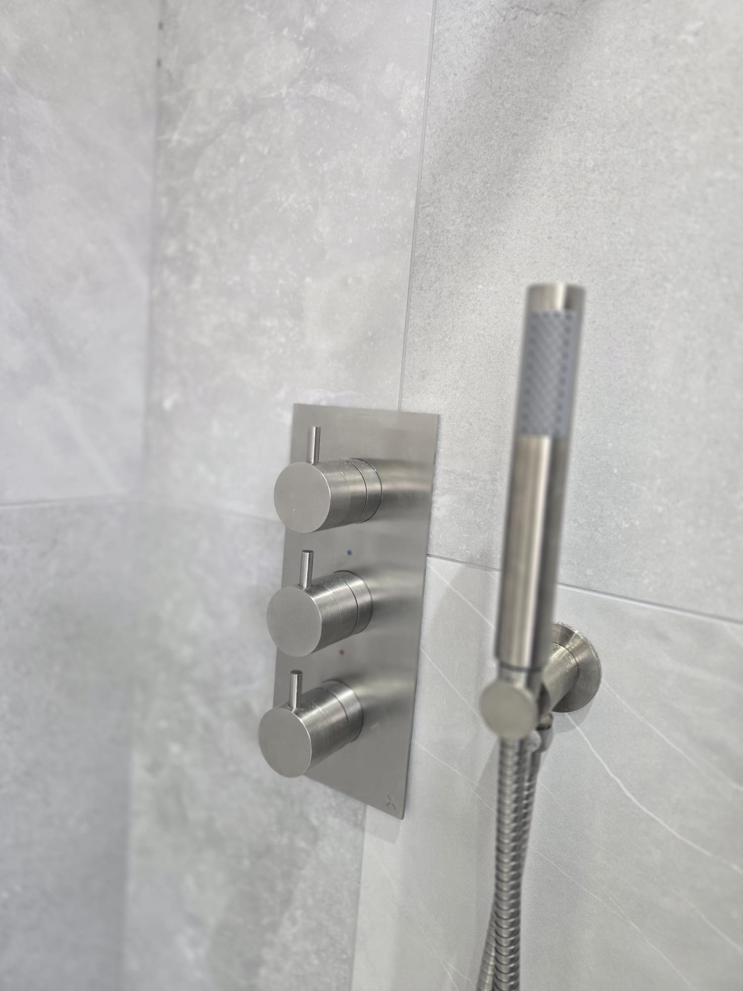 https://fixandflip.sdsdigitalsolutions.com/wp-content/uploads/2026/08/brushed-steel-shower-valve-handset-detail.jpg