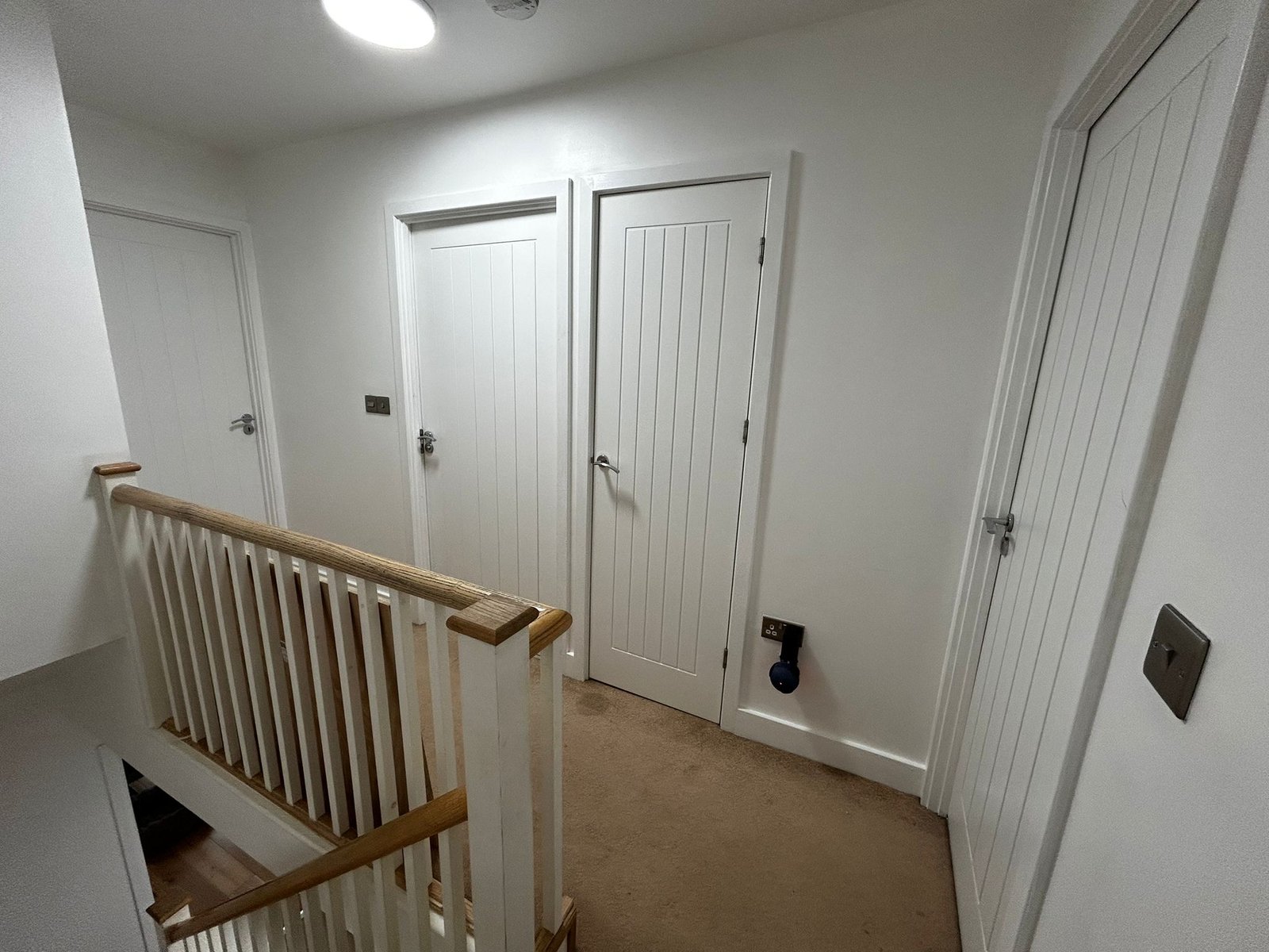 https://fixandflip.sdsdigitalsolutions.com/wp-content/uploads/2026/08/upstairs-landing-white-doors-staircase.jpg